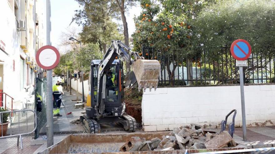 Operarios arreglan el muro de un colegio de Marbella.