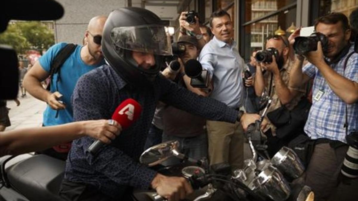 Yanis Varoufakis, rodeado de cámaras al abandonar ayer su oficina.