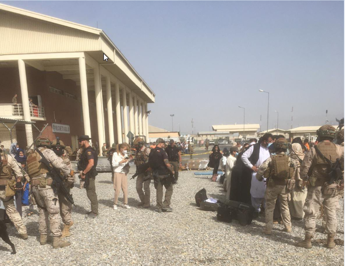 Policías y militares españoles reciben refugiados en el aeropuerto de Kabul, en una imagen difundida este sábado por el Ministerio de Defensa.