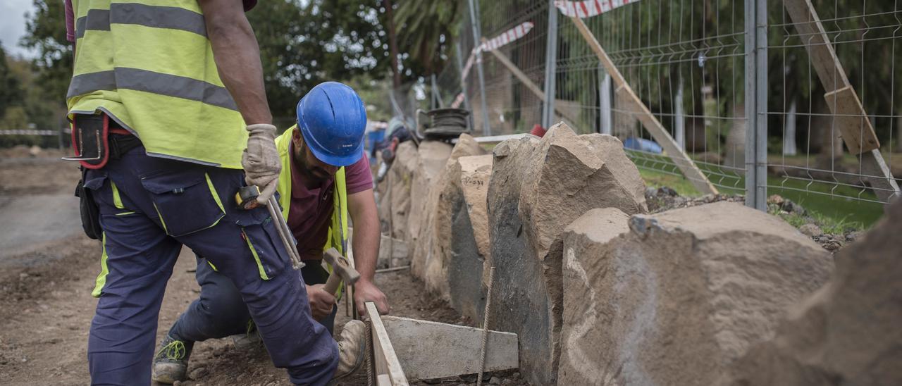 Dos obreros trabajan en la reforma de un parque público.