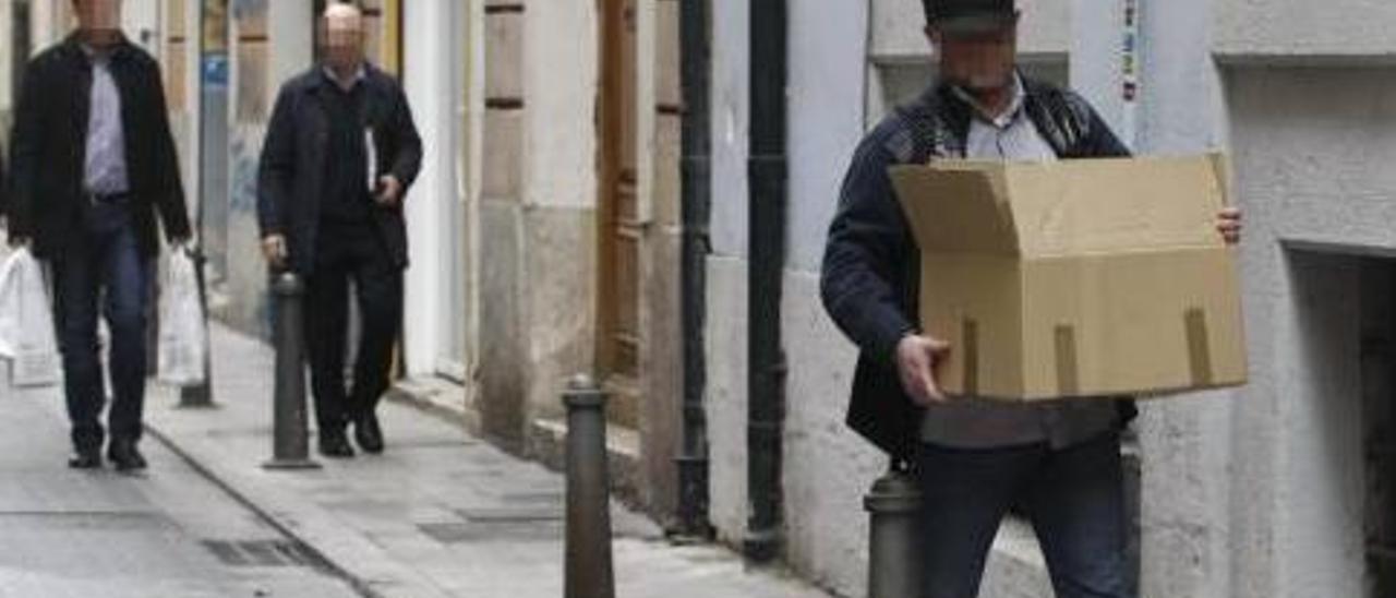 Agentes de la Guardia Civil salen del registro practicado ayer cargados con cajas y bolsas.