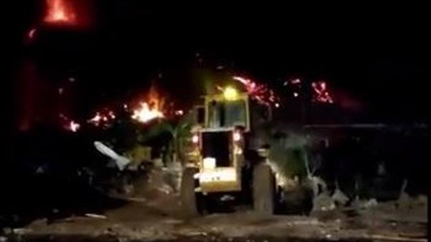 Bomberos de Gran Canaria tratan de encauzar el río de lava junto al barranco de la iglesia de Todoque.