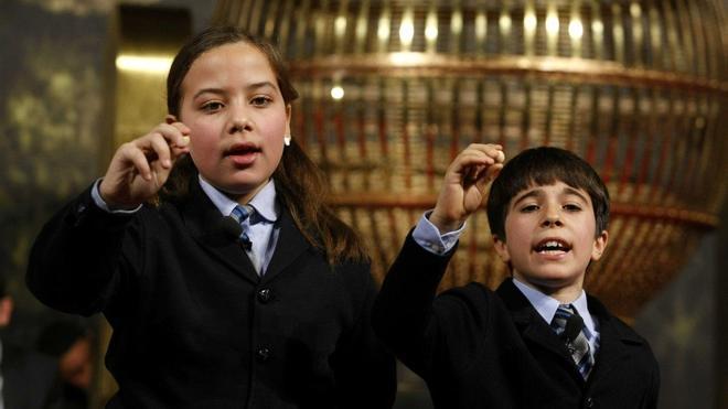 Niños de San Ildefonso cantando los premios de la Lotería de Navidad.