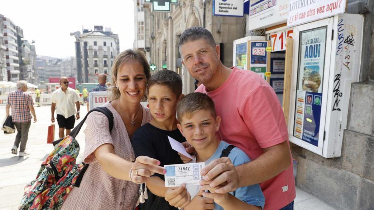 Una familia posa con un décimo del Gordo comprado ayer.  | // P.H.