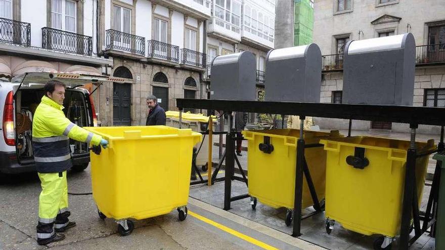 Un operario coloca contenedores nuevos en la calle San Nicolás.