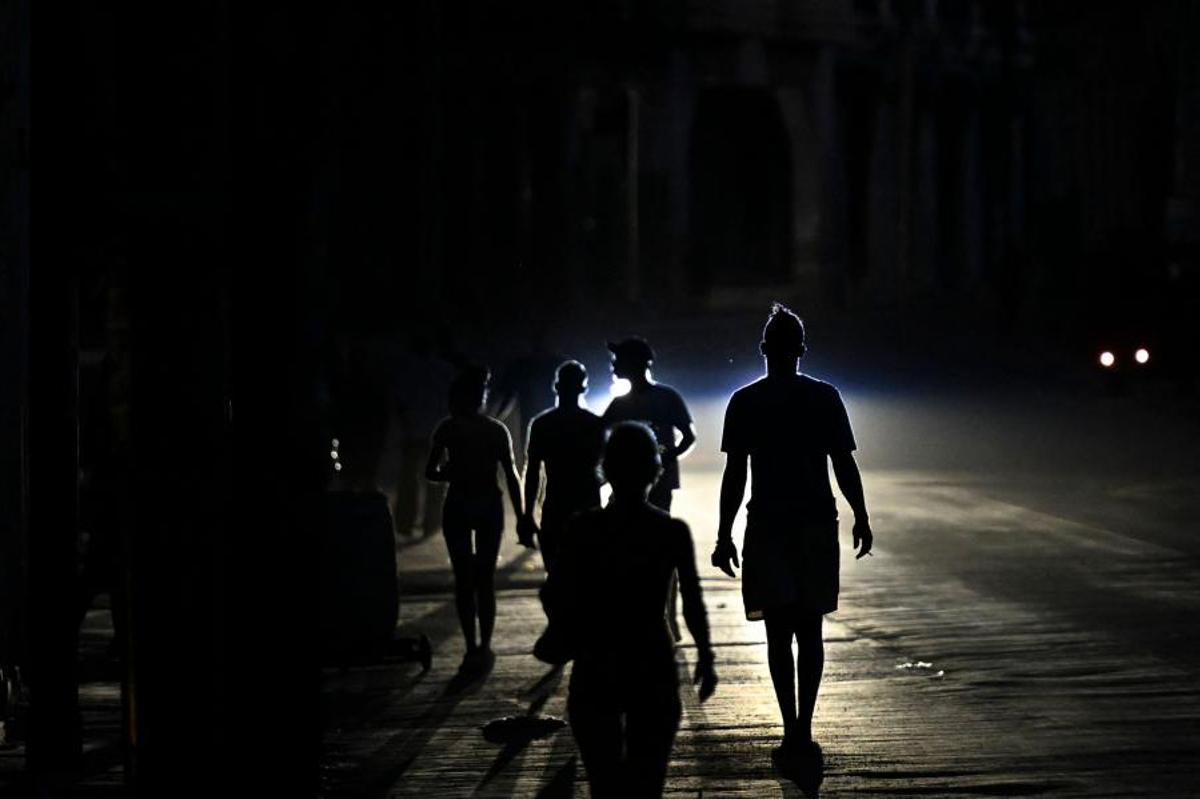 Personas caminan por una calle durante un apagón en La Habana, Cuba, el 13 de mayo de 2026. El gobierno cubano atribuyó a Estados Unidos la situación “particularmente tensa” de su red eléctrica, afectada por apagones prolongados, mientras Washington ha ofrecido nuevamente 100 millones de dólares en ayuda a la isla.