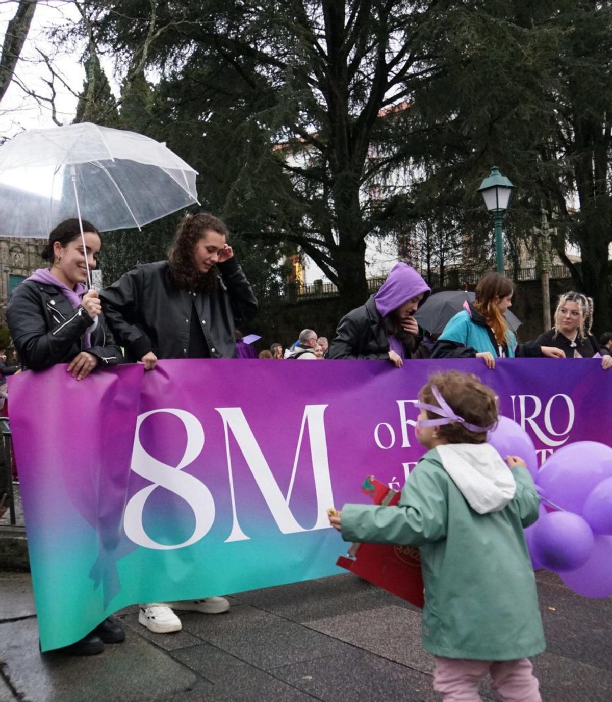 Una niña fijándose en una de las pancartas del 8M / jesús prieto