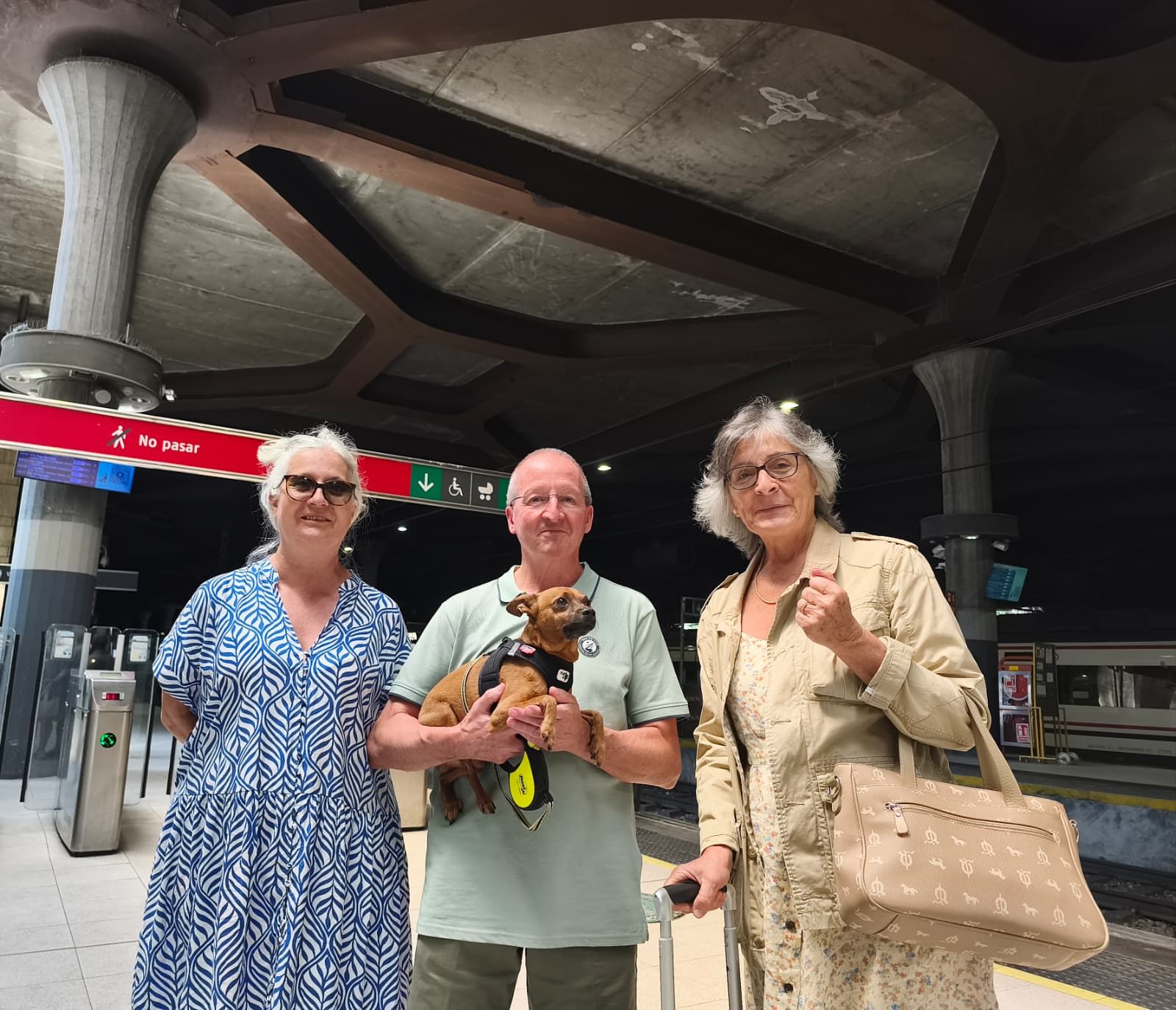 Los madrileños Noemí (izquierda), Adolfo e Isabel, con su mascota en el andén de la Estación de tren en Oviedo