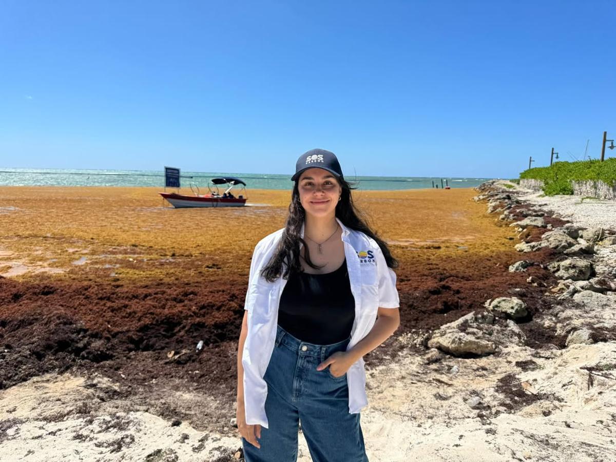 La cofundadora de SOS Biotech, Elena Martínez, en una playa cubierta de sargazo.