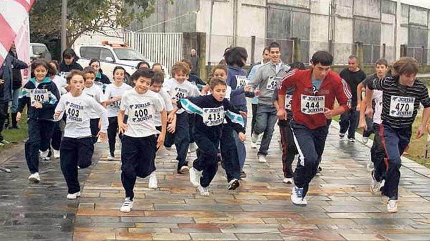 Los corredores al iniciar la carrera solidaria. En la imagen de la izquierda, uno de los ganadores, en primer plano.