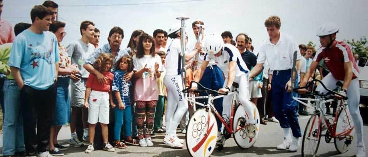 Arriba, José Manuel González Castrillón y José Manuel Peláez, con las antorchas en el muelle de Navia. A la izquierda, Pedro Peláez, Peláez y Castrillón, hace 24 años. Abajo, el grupo de voluntarios que llevó la antorcha por el Occidente.