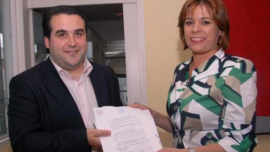 Héctor Otero y Clara Miilán muestran el documento notarial, antes del pleno.