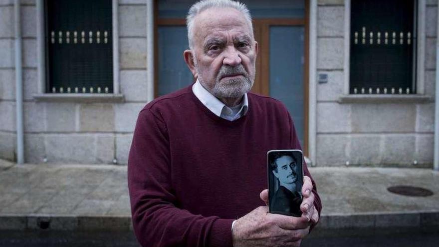 José Balboa, tío abuelo de Alberto Fornos, con una foto del joven emigrante asesinado, ante la casa familiar de Beariz. // Brais Lorenzo