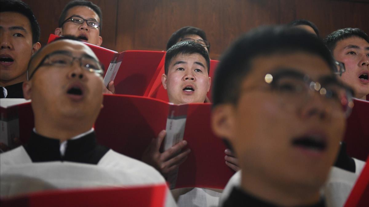 Un coro canta durante la misa de Jueves Santo, en Pekin.