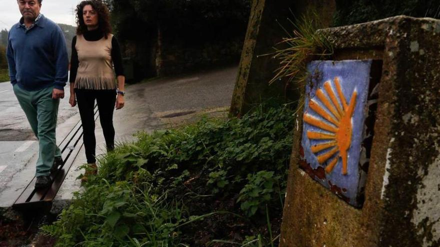 Montse Rodríguez y José Ramón López, junto al mojón que indica el Camino de Santiago en La Plata.