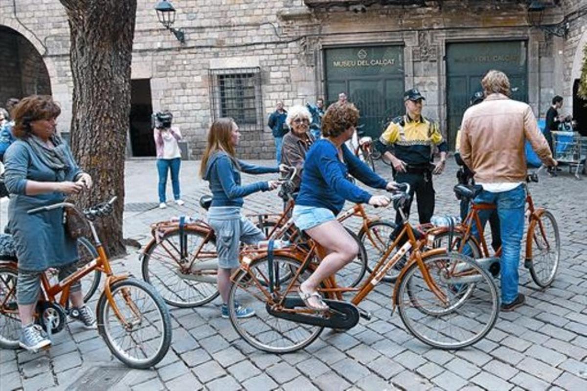 Un guardia urbano informa a varios turistas sobre las nuevas limitaciones del uso de la bicicleta por las calles de Ciutat Vella, el pasado mayo.