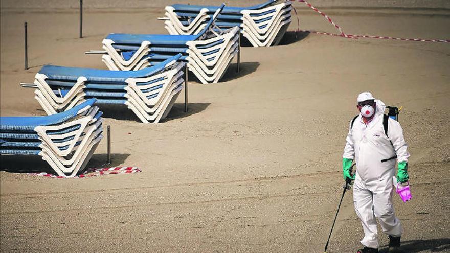 Un operario realiza tareas de desinfección en una playa de Las Vistas sin turistas.