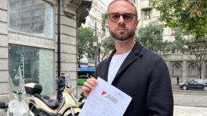 El activista bielorruso Andréi Gnyot posa con una carta firmada por 783 artistas pidiendo su liberación al Gobierno serbio.