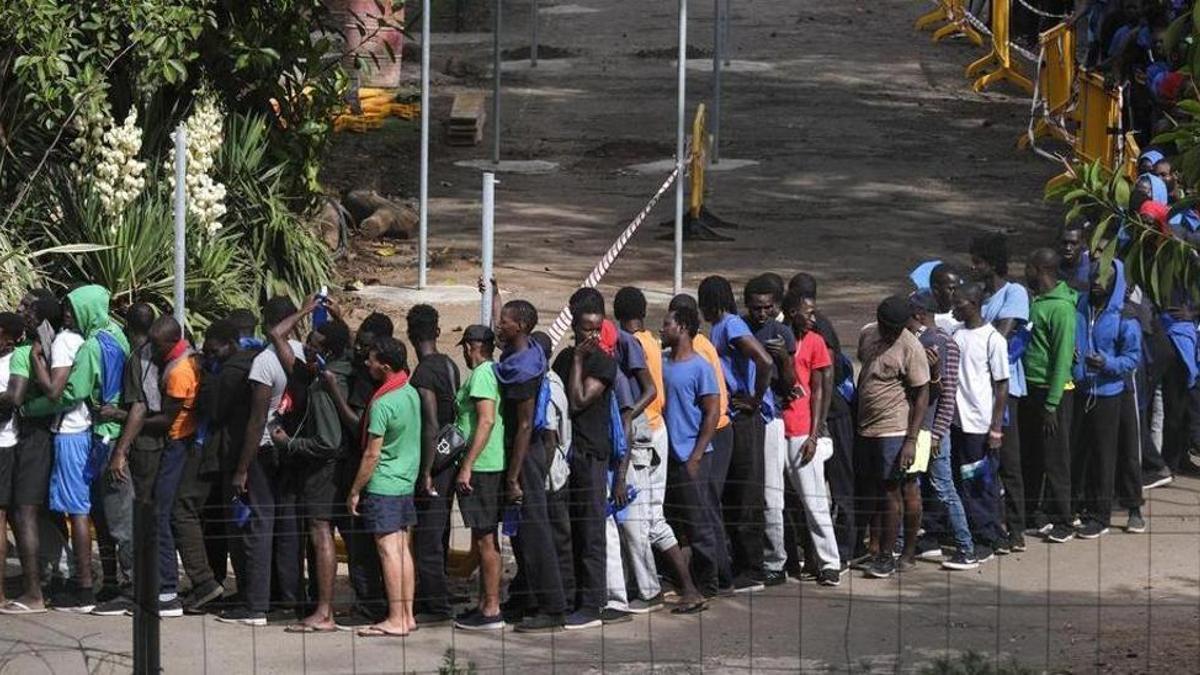 Colas de migrantes en el campamento de las Raíces, en Tenerife, este lunes.
