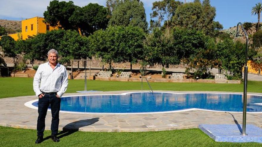 Luis Sicilia en la explanada de la piscina del hotel rural Maipez, al fondo entre árboles.