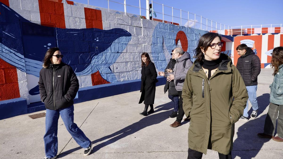 NIeves Roqueñí, en primer término, con los ilustradores Vera Galindo (primera por la izquierda) y Juan Rubio (tras Roqueñí, a la derecha) junto al mural que pintaron estos últimos.