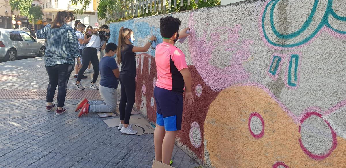 Alumnos trabajan en el mural de la fachada del San José de Calasanz.