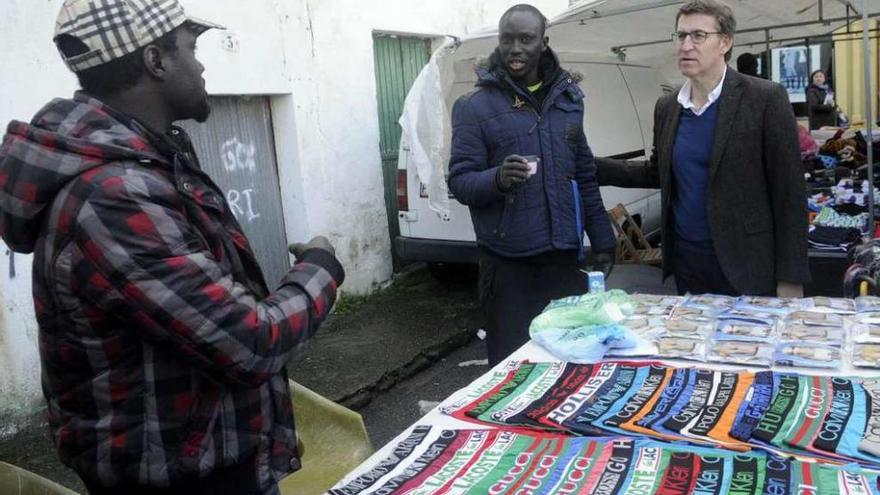 El presidente Núñez Feijóo con los vendedores ambulantes africanos en el mercadillo. // Noé Parga