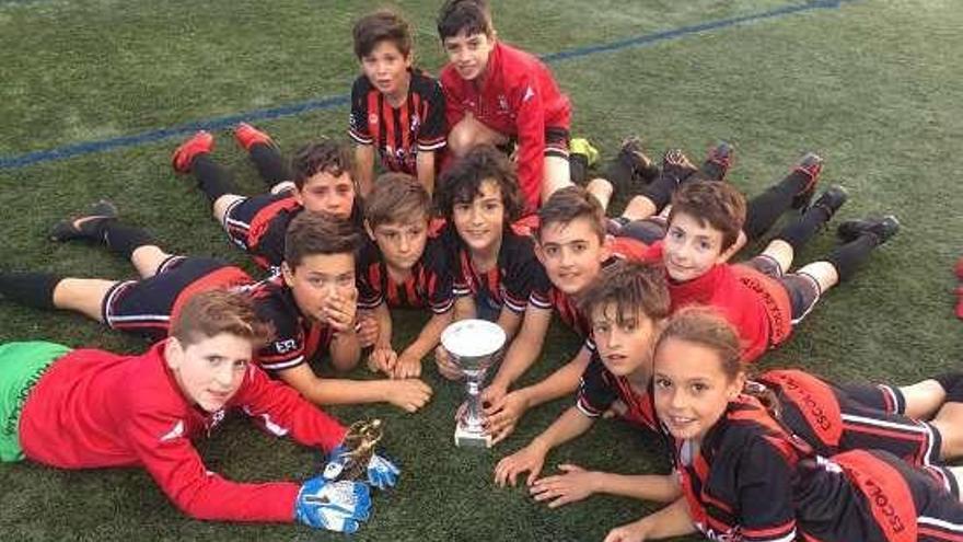 Los jugadores rojinegros posan con su trofeo.