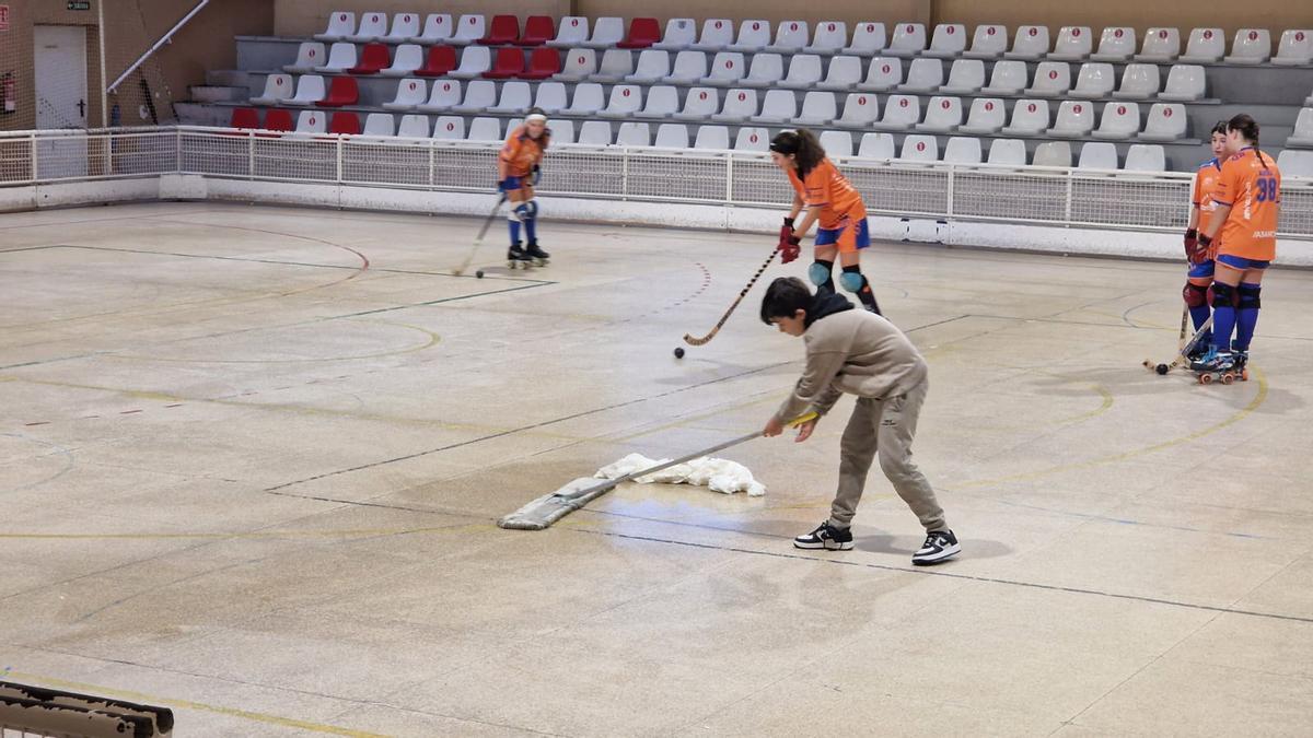 Tratan de secar la pista del pabellón de O Carmen mojado por las goteras.