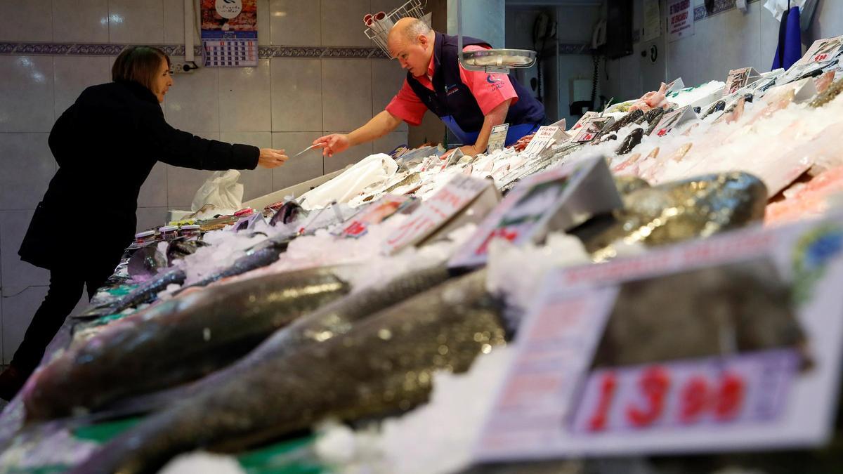 Un pescatero atiende a un cliente.