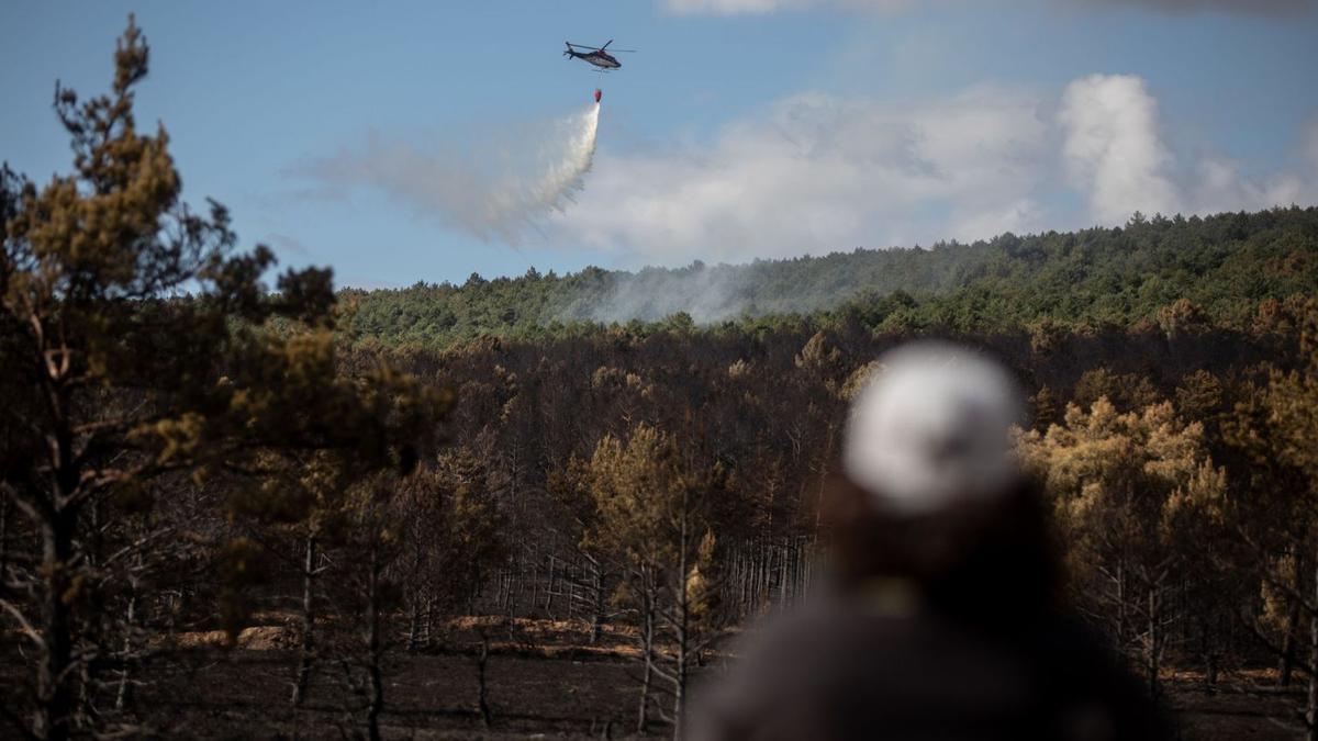 Un helicóptero actúa para prevenir la reactivación del fuego. |