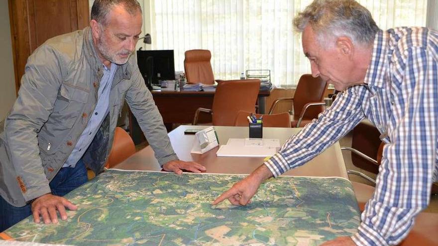 El alcalde y el concejal de Urbanismo observan un mapa del municipio.