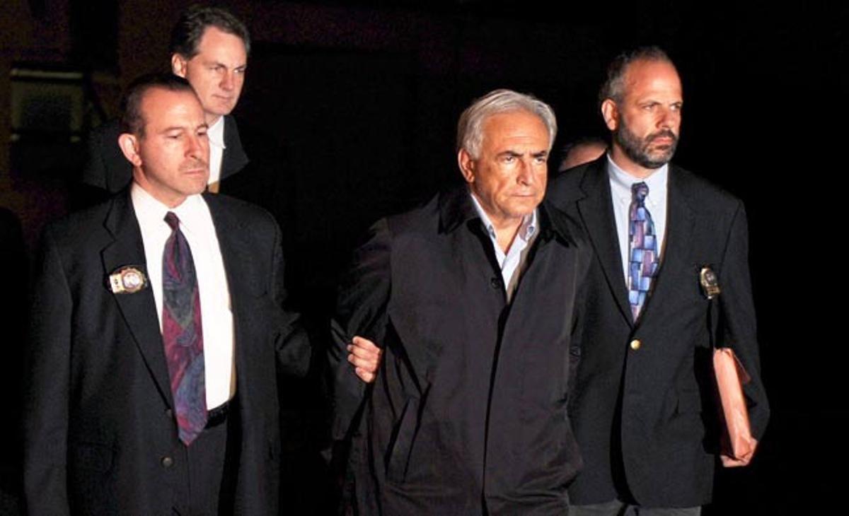 L’actual director general del Fons Monetari Internacional (FMI), Dominique Strauss-Kahn, camina detingut per la policia després que una treballadora d’un hotel novaiorquès el denunciés per un presumpte abús sexual.