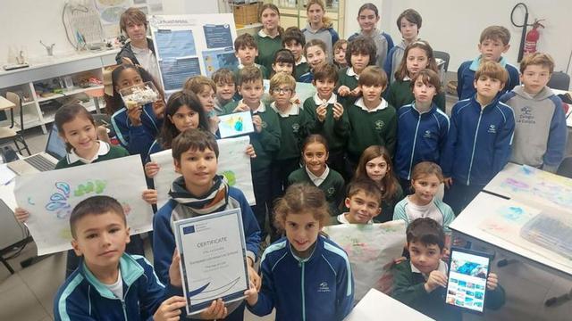 Alberto Costales, Alejandro Sambad y Sofía Aarné, con el certificado, junto a más alumnos del colegio La Corolla, en el laboratorio del centro. | S. G.