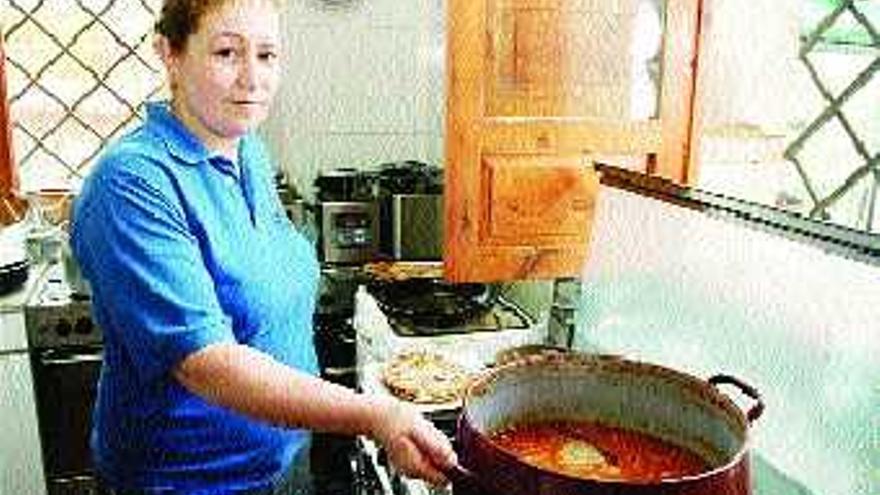 La cocinera Beatriz Fernández, en la cocina del centro social de El Carmen, con una fabada.