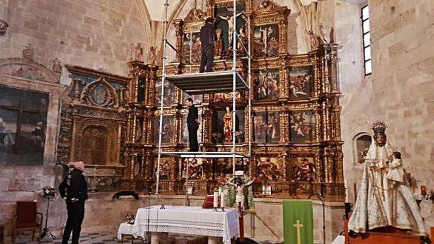 Los operarios instalan en el retablo mayor de la iglesia de Nuestra Señora de la Asunción las tallas cedidas.