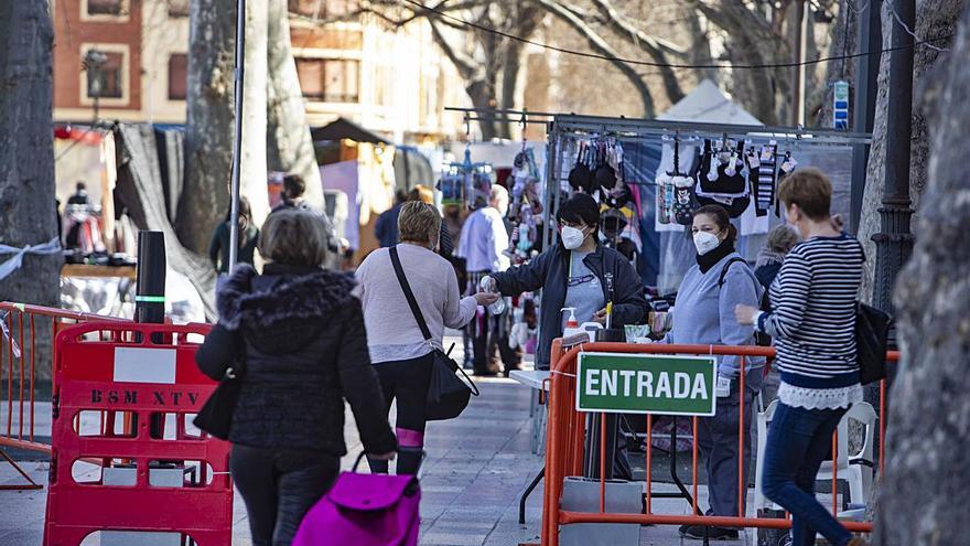 Dos vecinas de Xàtiva caminan hacia la entrada al mercado ambulante, en una imagen de ayer | PERALES IBORRA