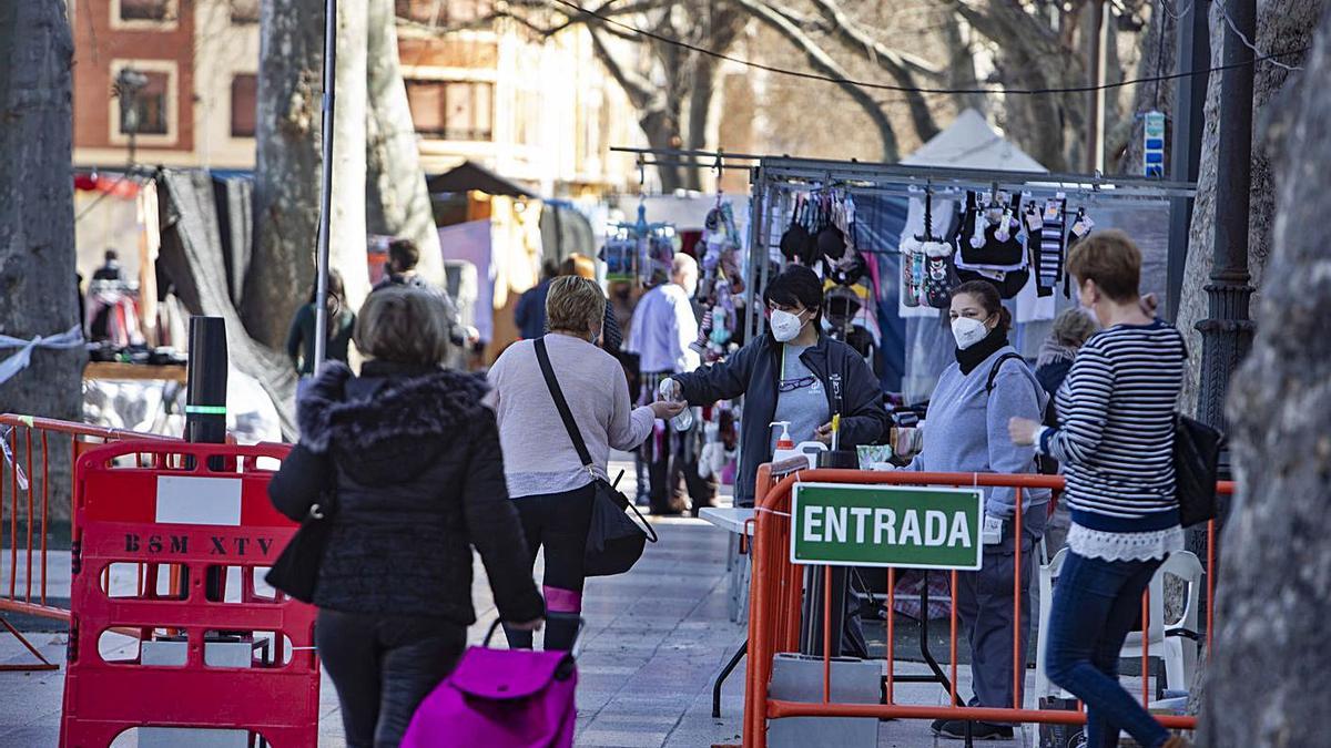 Dos vecinas de Xàtiva caminan hacia la entrada al mercado ambulante, en una imagen de ayer | PERALES IBORRA