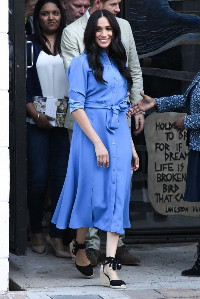 Meghan Markle con un vestido midi camisero en color azul y unas alpargatas de la forma española Castañer en su primer día en Sudáfrica