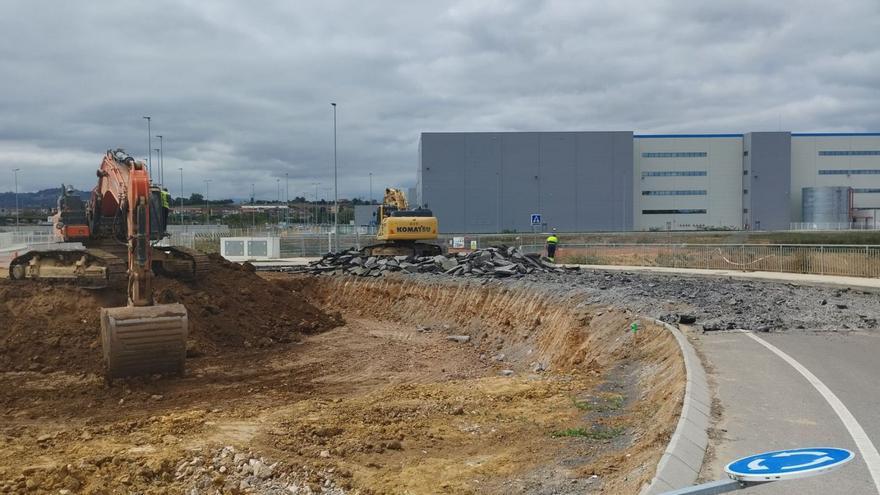 Las obras de desdoblamiento de la AS-17 en el polígono de Bobes, con la nave de Amazon al fondo.