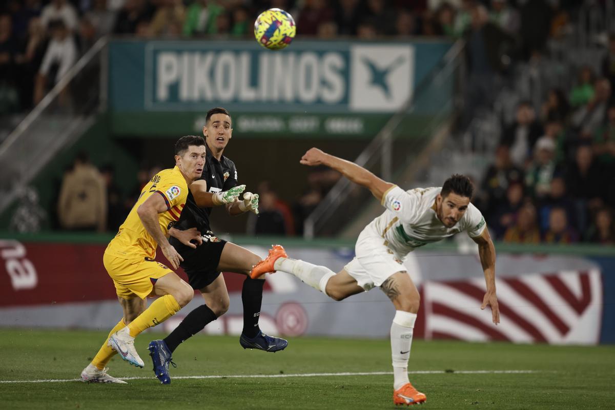 Elche (Alicante), 01/04/2023.- El defensa del Elche, Pedro Bigas (d), despeja el balón ante el delantero polaco del FC Barcelona, Robert Lewandowski, durante el encuentro correspondiente a la jornada 27 de LaLiga Santander que disputan hoy sábado en el estadio Manuel Martinez Valero de la localidad alicantina. EFE/Biel Aliño.