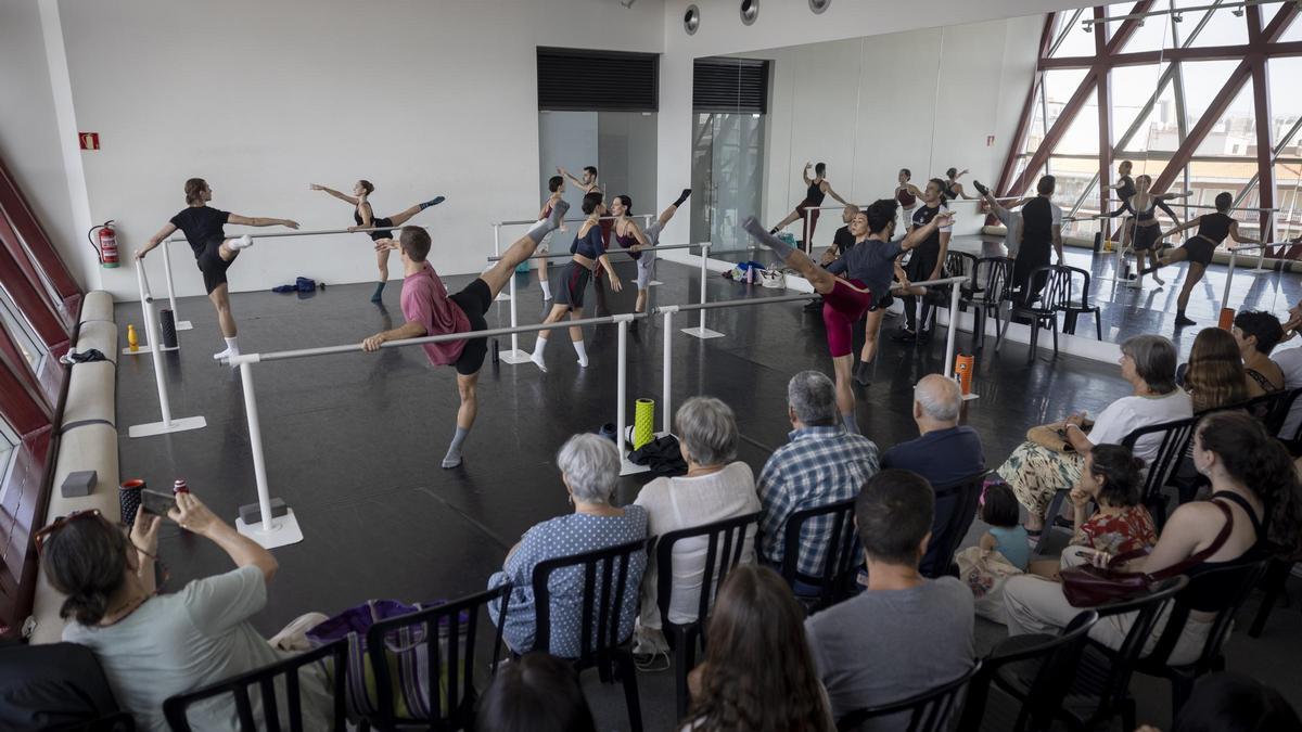 Los asistentes al ensayo observan a los bailarines durante sus ejercicios de calentamiento en barra, ayer.