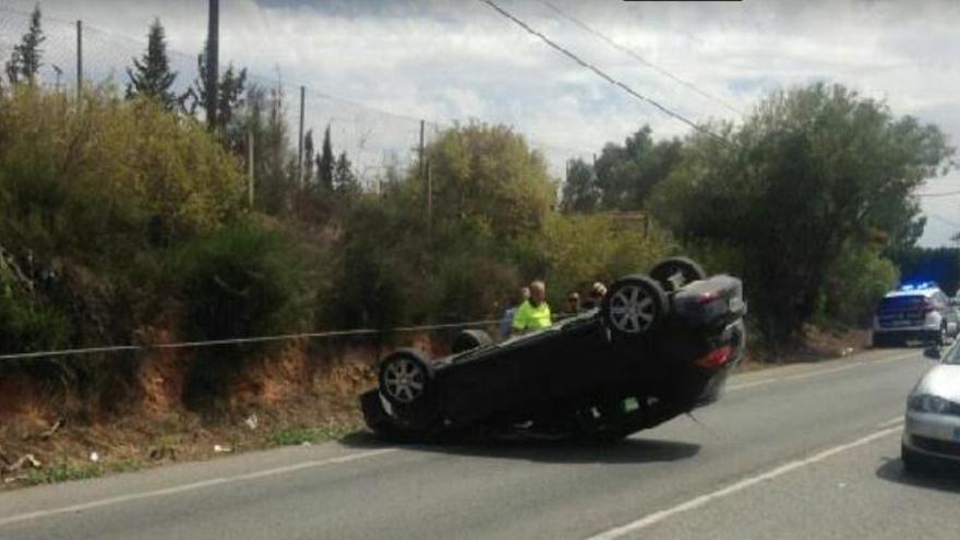 El coche, volcado en la carretera