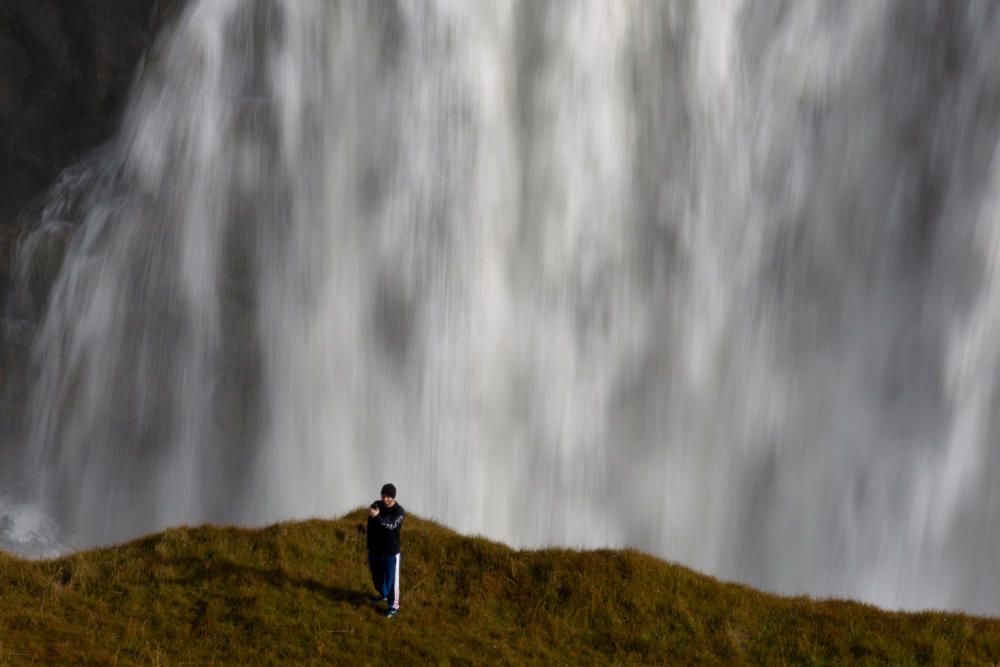 Un turista toma una fotografía selfie en un área prohibida para caminar, con vistas a las cascadas en Gullfoss, Islandia.