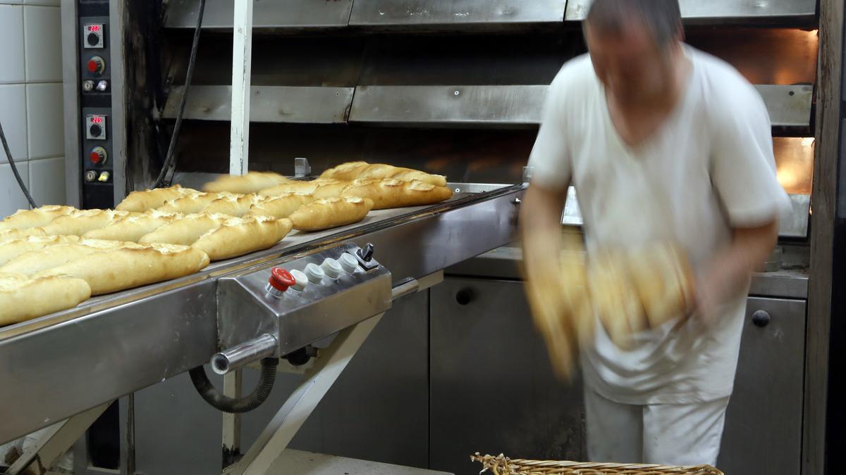 Un panadero sacando producto del horno en un establecimiento de Zaragoza.