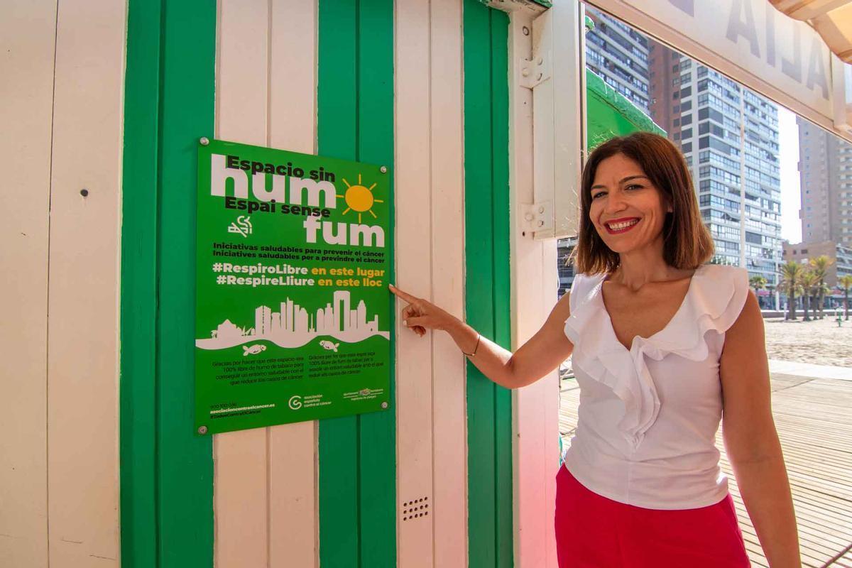 La concejal de Playas junto a uno de los carteles que informan que es un espacio libre de humos