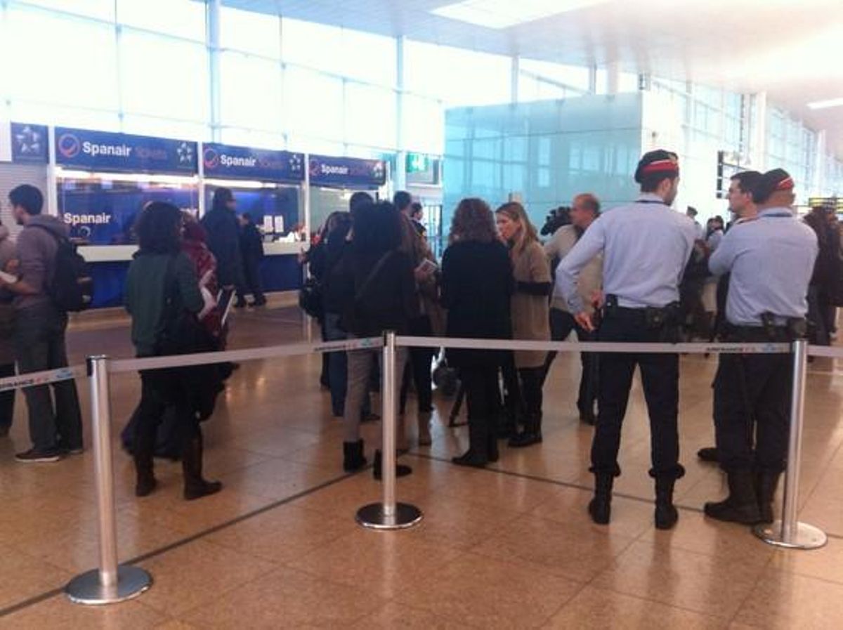 Dos agents dels Mossos d’Esquadra observen diversos passatgers davant els taulells de Spanair, aquest dissabte, al Prat. Dos agents dels Mossos d’Esquadra observen diversos passatgers davant els taulells de Spanair, aquest dissabte, al Prat.