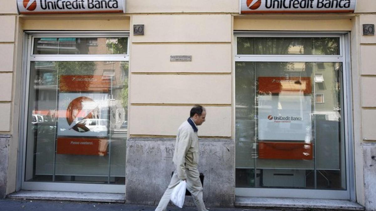 Un hombre pasa frente a una oficina de Unicredit en Milán.