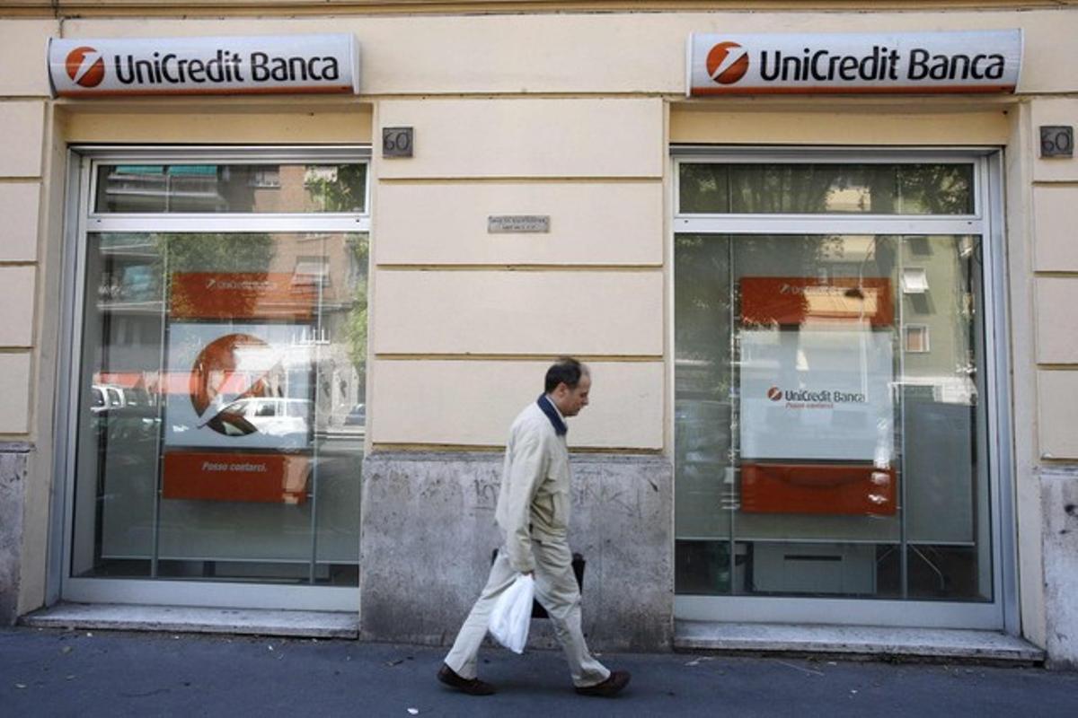 Un home passa davant d’una oficina d’Unicredit a Milà.