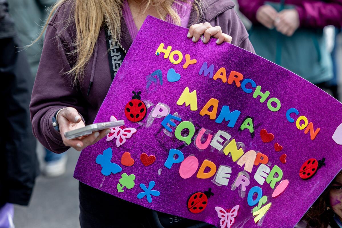 Manifestante porta pancarta con lema 'Hoy marcho con mamá. Pequeña pero poderosa' durante la manifestación organizada por el Movimiento Feminista de Madrid por el 8M.